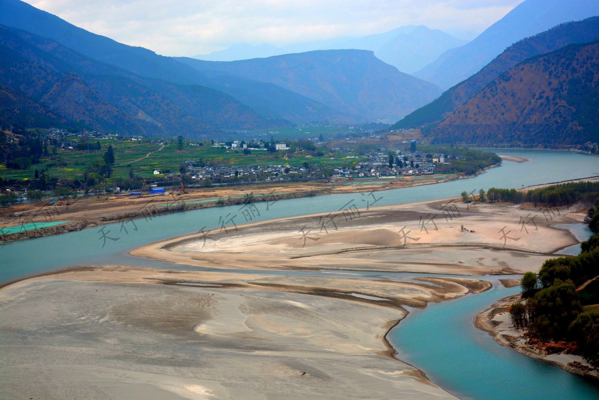 “長(zhǎng)江第一灣”位于麗江市玉龍縣石鼓鎮(zhèn)，萬(wàn)里長(zhǎng)江從“世界屋脊”青藏高原奔騰而下，由滇西北進(jìn)入云南，與瀾滄江、怒江一起并肩穿行在橫斷山脈的高山深谷之中，造就了“三江并流”的罕見(jiàn)壯麗景觀。 到了石鼓鎮(zhèn)，奔騰而下的滾滾長(zhǎng)江被山崖阻擋，突然來(lái)了個(gè)180度的急轉(zhuǎn)彎，形成了“V”字形大彎，“江流到此成逆轉(zhuǎn)，奔入中原壯大觀”，人們稱(chēng)這天下奇觀為“長(zhǎng)江第一灣”。